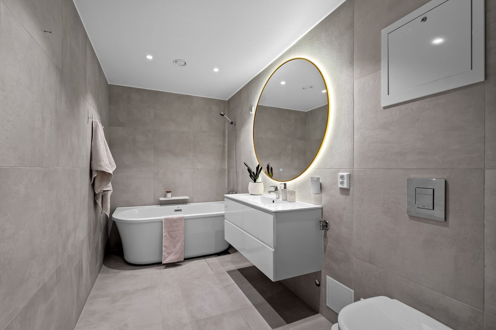 Det store hovedbadet ligger i boligens 1. etasje. Her finner du lyse, delikate storformatfliser på både gulv og vegger, som gir et rent og stilfullt uttrykk. Galleribilde