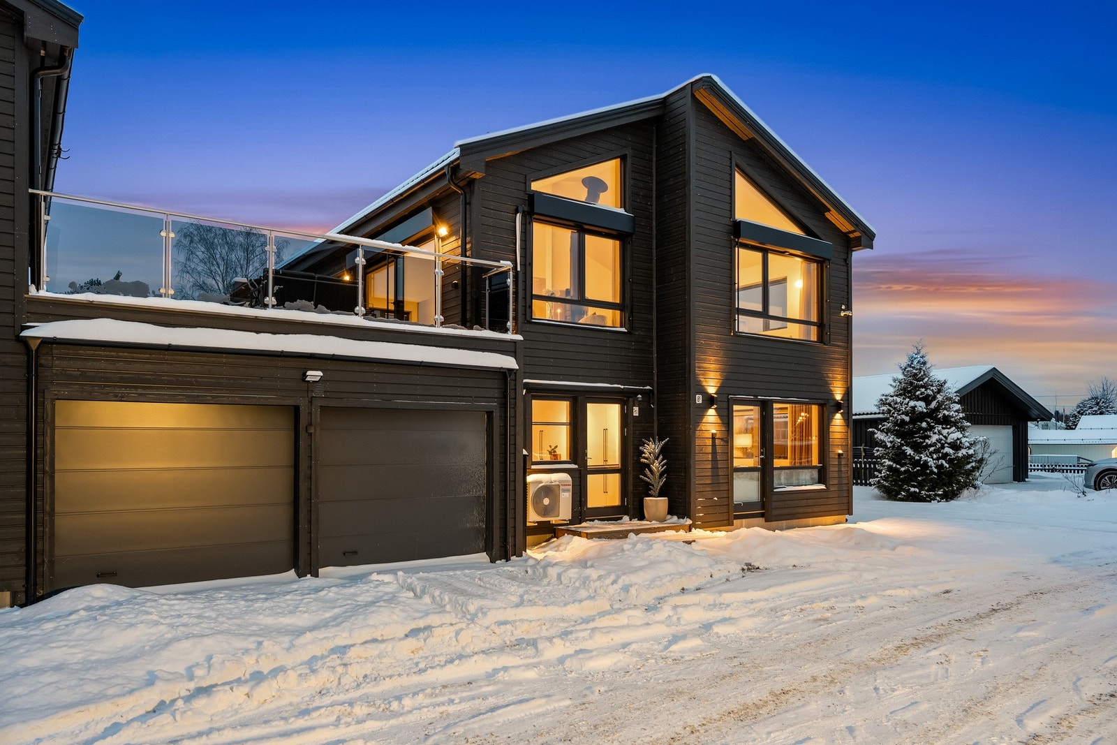 Parkering i sidestilt dobbelgarasje med praktisk sportsbod i bakkant. Det er intern tilgang fra garasjen og inn i boligen. Galleribilde