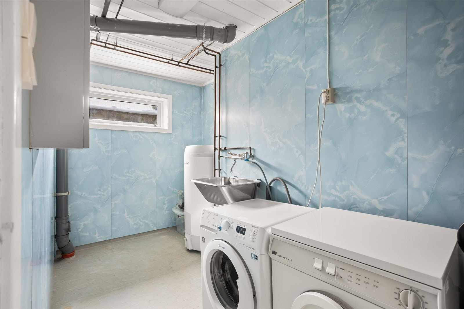 Separat og romslig vaskerom i underetasjen med utslagsvask og opplegg for vaskemaskin. Galleribilde