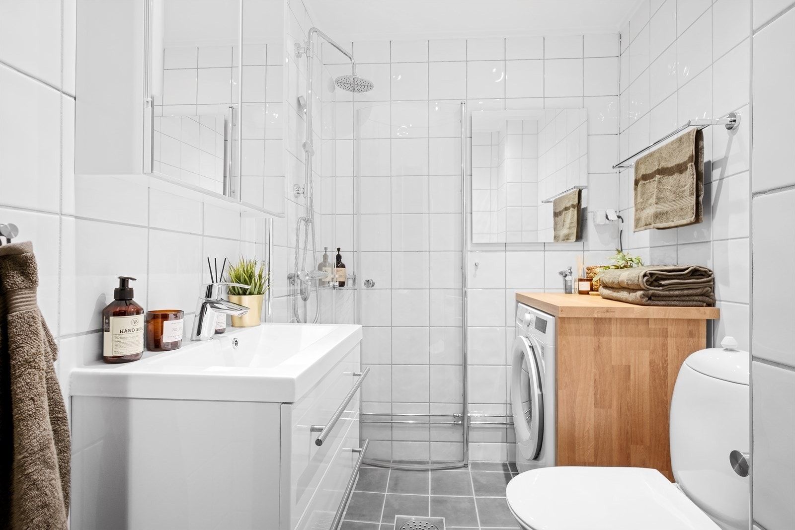 Delikat, flislagt bad med varmekabler og opplegg for vaskemaskin - praktisk i hverdagen. Galleribilde