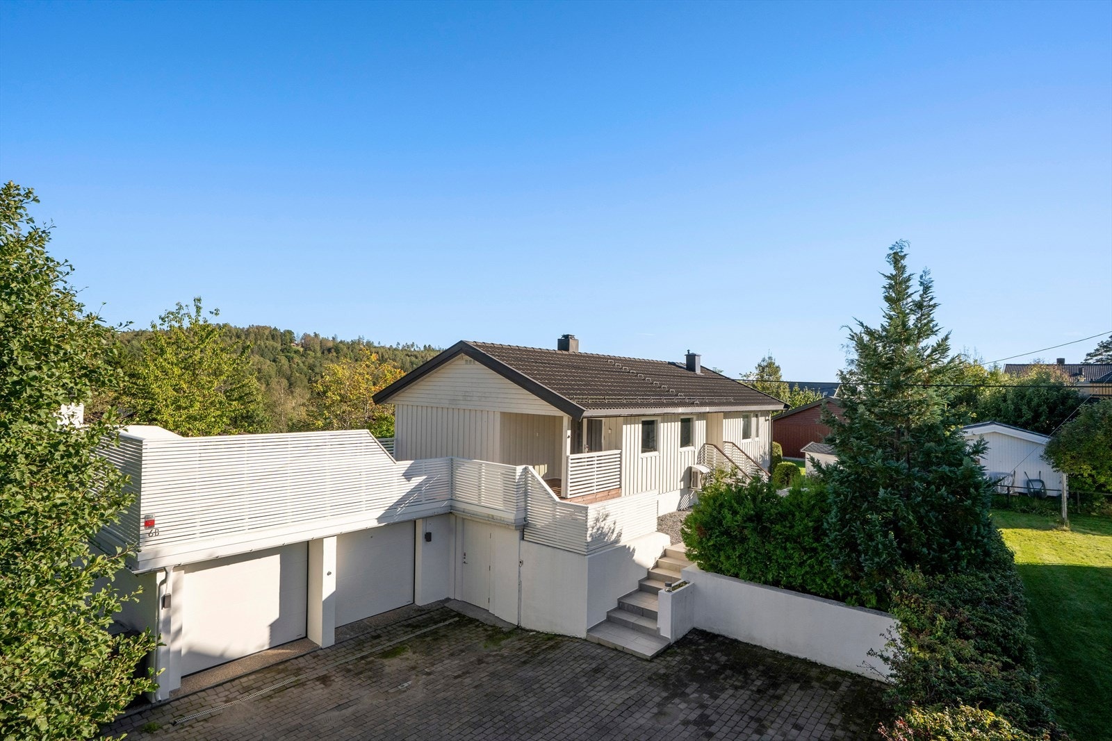 Her er det romslig og steinbelagt gårdsplass foran dobbeltgarasjen med el. porter Galleribilde