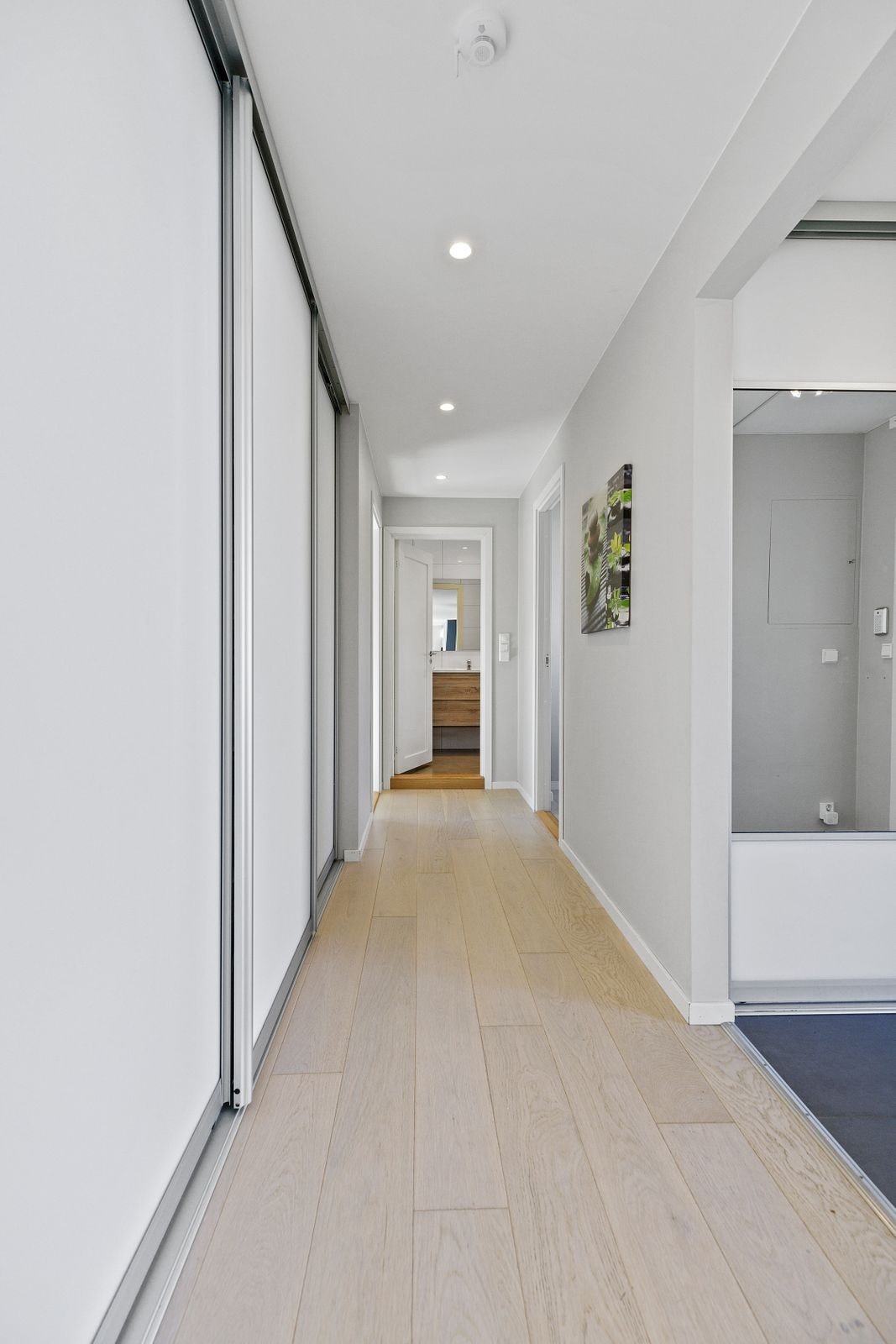 Påfølgende gang fra entreen er praktisk innredet med enda flere skyvedørsgarderober. Galleribilde