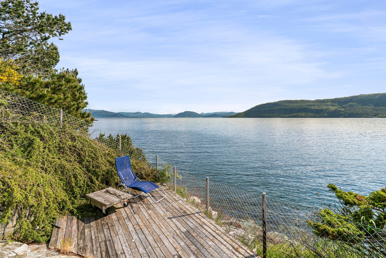 Rundt hovedbygningen finnes gressplen, busker og enkle hagefelt, samt terrasse og platting med utsikt mot sjøen. Galleribilde