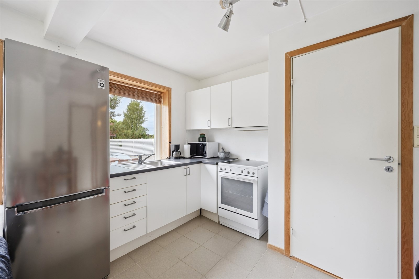 Stilrent kjøkken med frittstående komfyr og kjøl/frys. Galleribilde