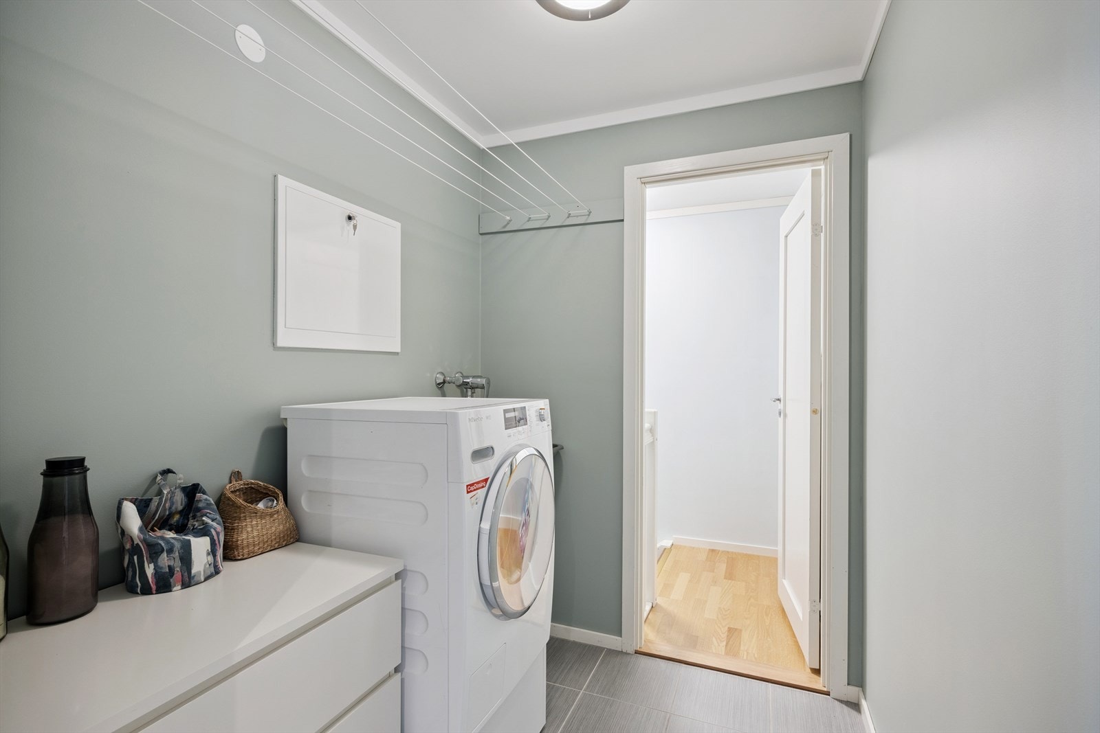 Praktisk separat vaskerom med opplegg for vaskemaskin og skyllekar på vegg. Galleribilde