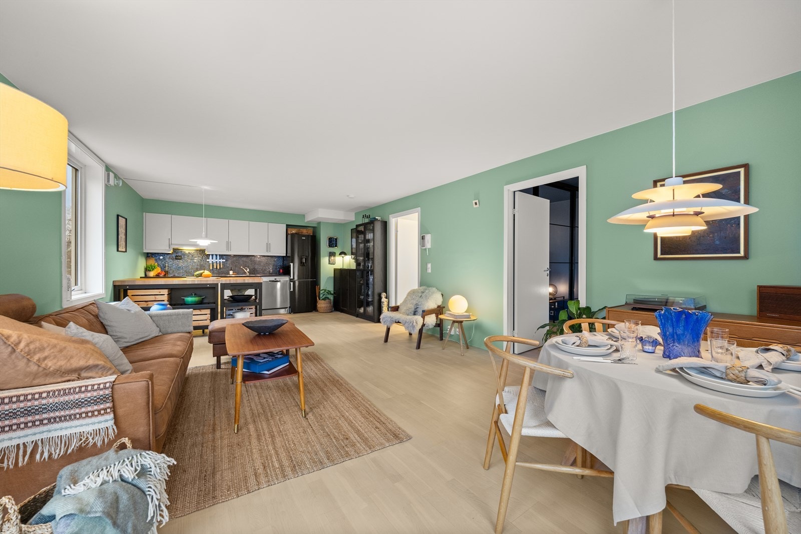 Stue og kjøkken er i en åpen løsning som bidrar til et sosialt oppholdsrom Galleribilde