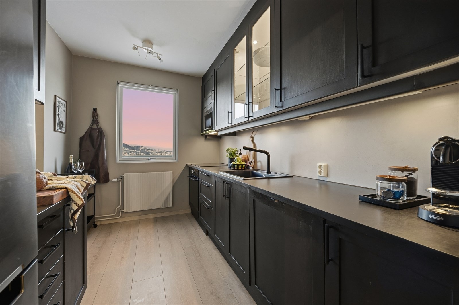 Kjøkkenet har malte profilerte fronter og delvis integrerte hvitevarer Galleribilde