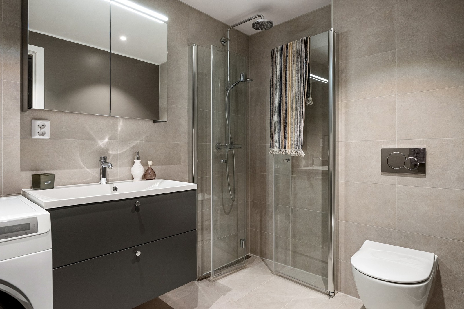 Delikat og meget pent flislagt bad med gulvvarme og opplegg for vaskemaskin. Galleribilde