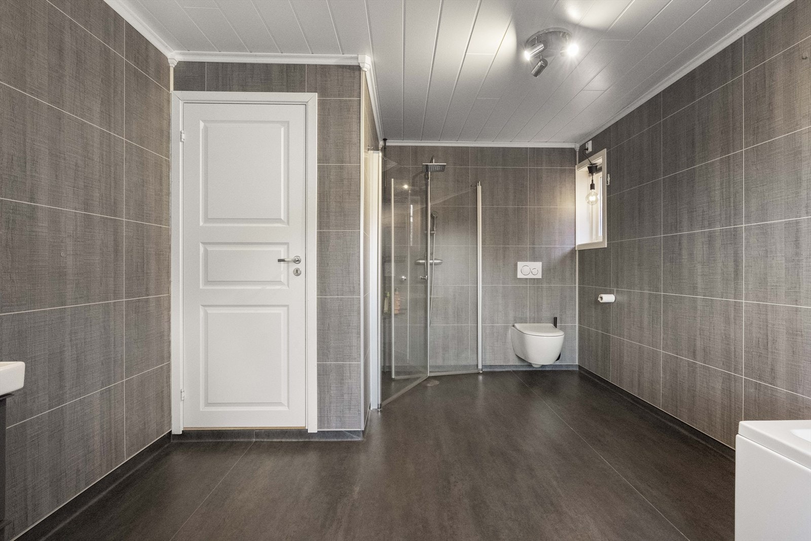 Badet er av god størrelse innreda med bla. dusjhjørne, badekar og dobbel servant Galleribilde