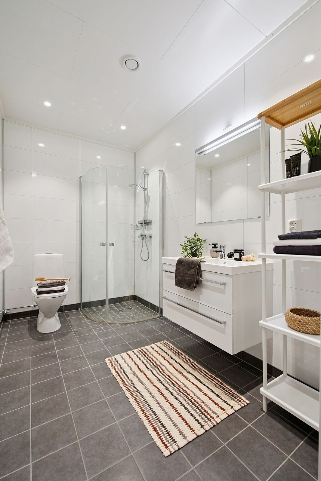 Lyst og pent bad med fliser på gulv og våtromsplater på veggene. Galleribilde