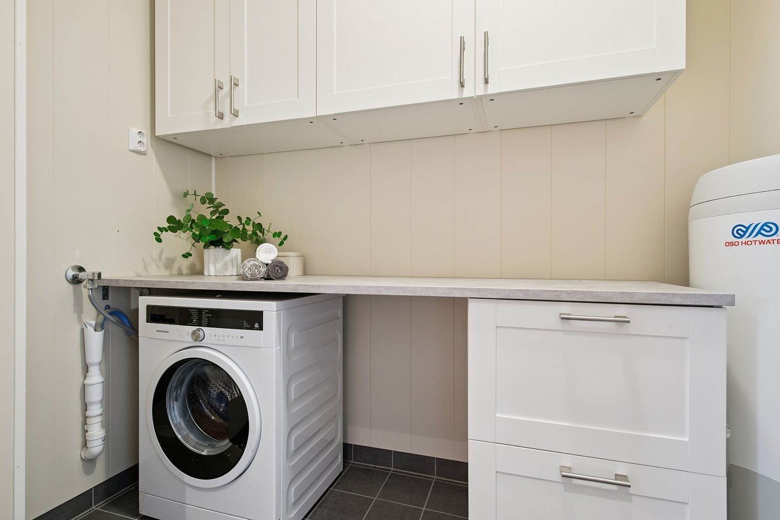 Her er det opplegg for vaskemaskin, en 200-liters varmtvannsbereder og god lagringsplass. Galleribilde