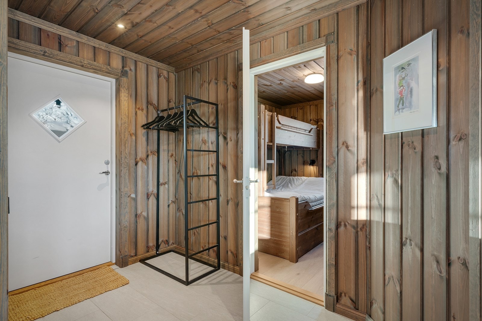 Velkommen inn! Hytten har en romslig entré med god plass å henge fra seg yttertøy og sko og det er varmekabler i gulv. Galleribilde