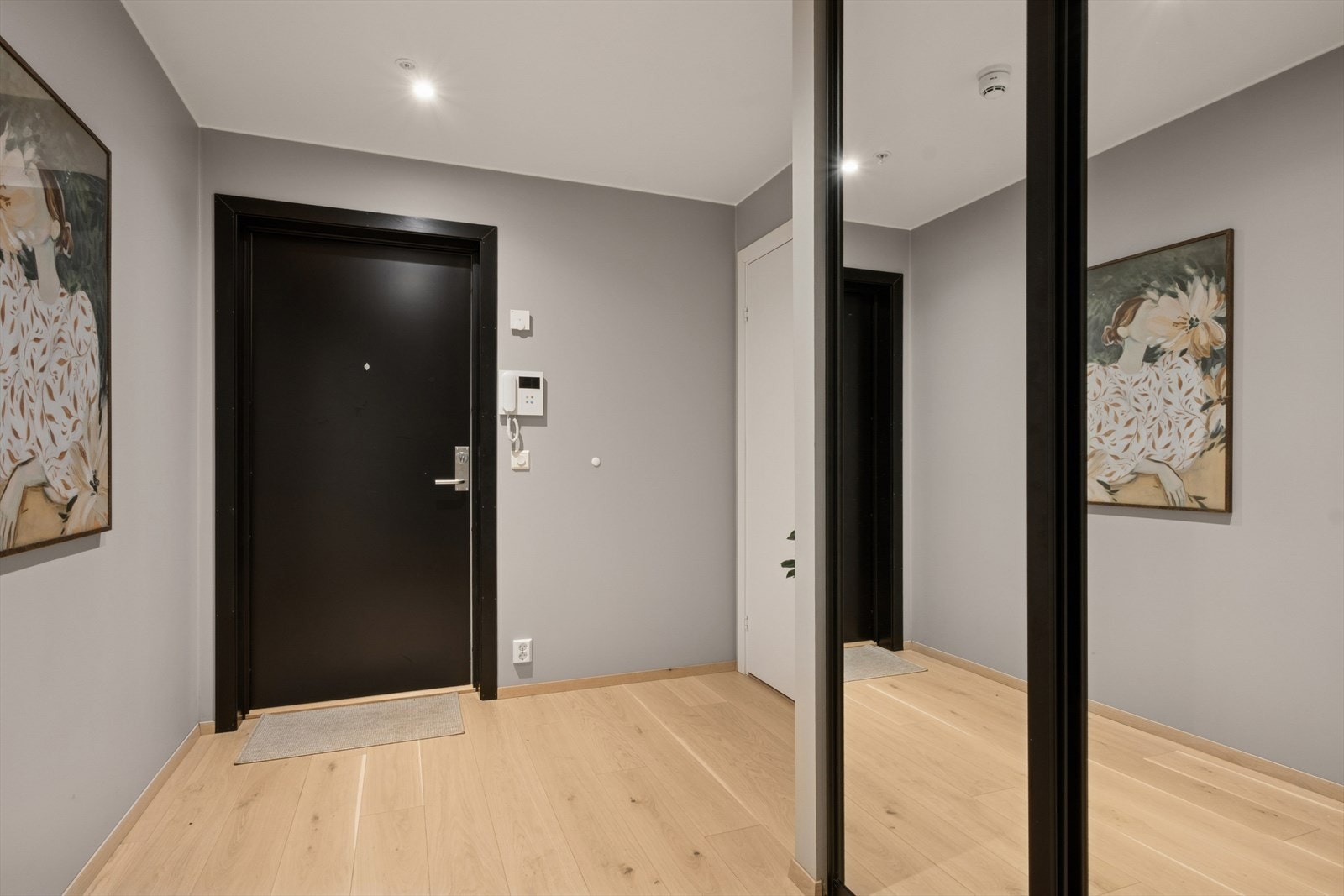 Entréen er romslig og har pent parkettgulv og glatte vegger, en stil som går igjen i hele leiligheten. Galleribilde