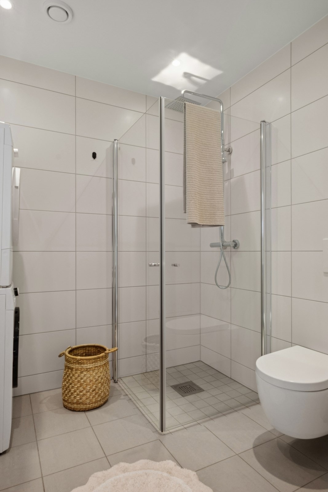 Dusjhjørne med både hånd- og regndusj, vegghengt toalett og opplegg for vaskemaskin på det ene badet. Galleribilde