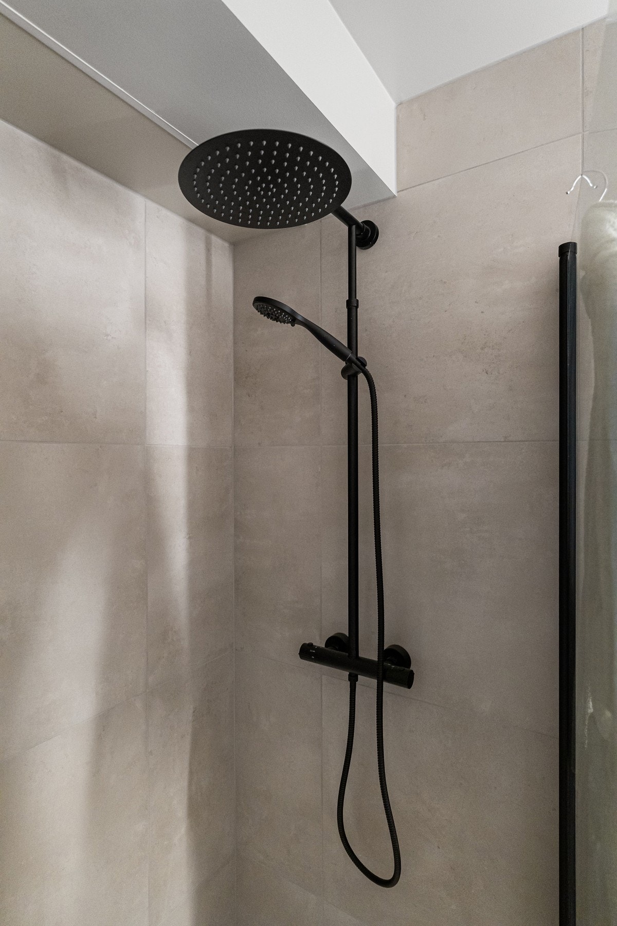 Baderommet er utstyrt med hjørnedusj i svarte detaljer og innfellbare dusjdører. Galleribilde