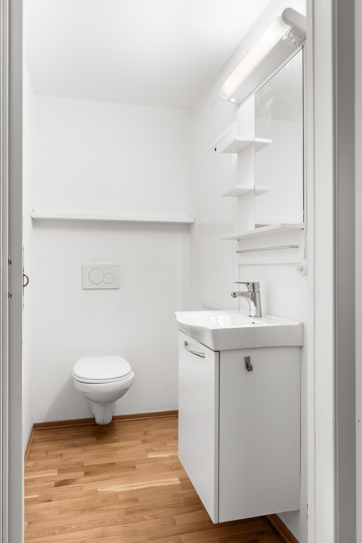 Toalettrom på 1,9 kvm. Utstyrt med vannfordelerskap, veggmontert wc, servantskap og servant. Galleribilde