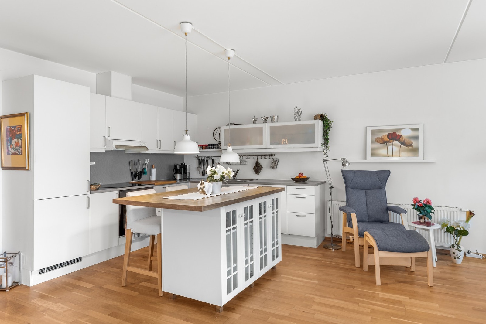 Lyst kjøkken med glatte og hvite kjøkkenfronter, med god plass for oppbevaring av redskap. Galleribilde