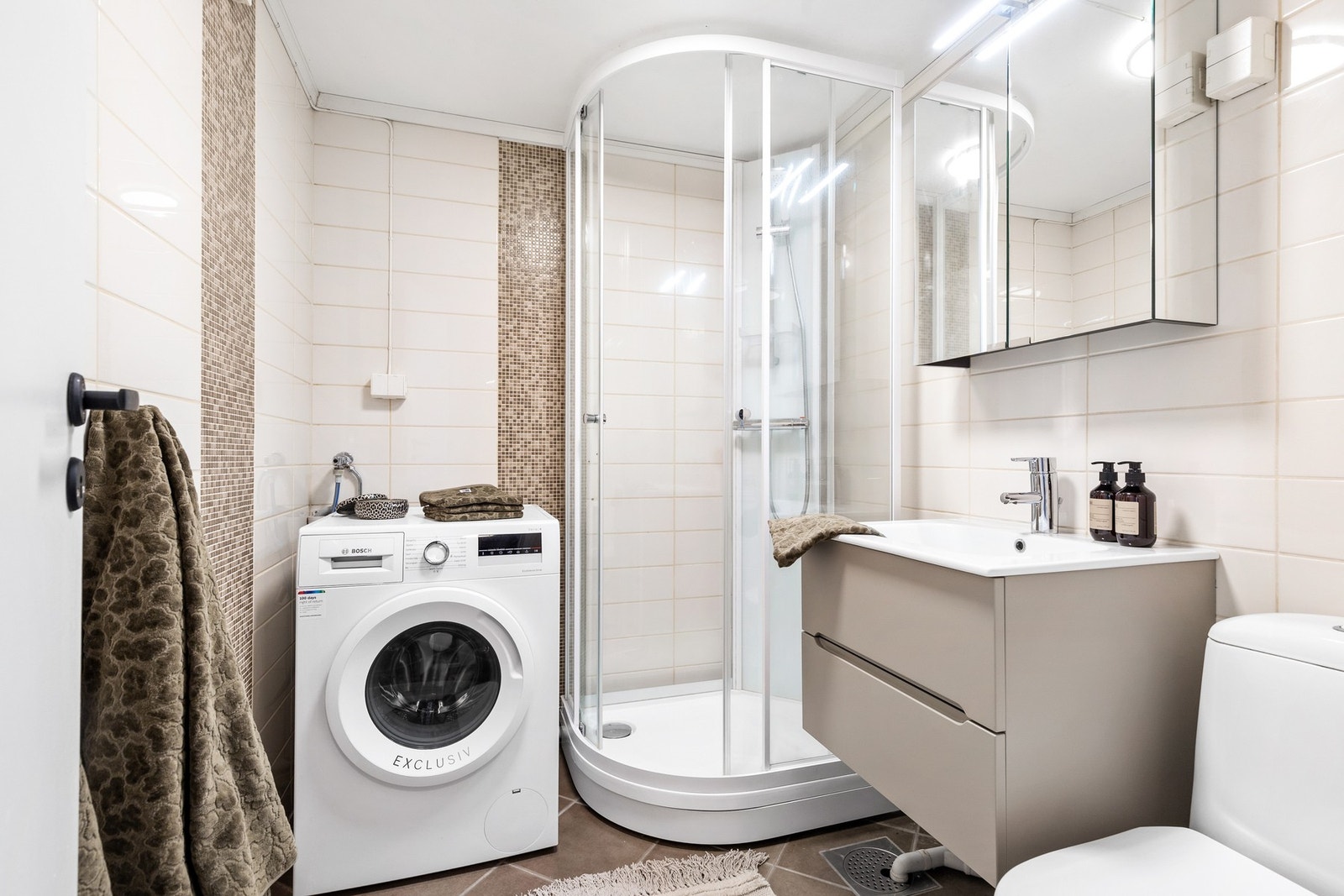 Badet består av klosett, servant med under- og overskap, dusjkabinett og opplegg for vaskemaskin Galleribilde