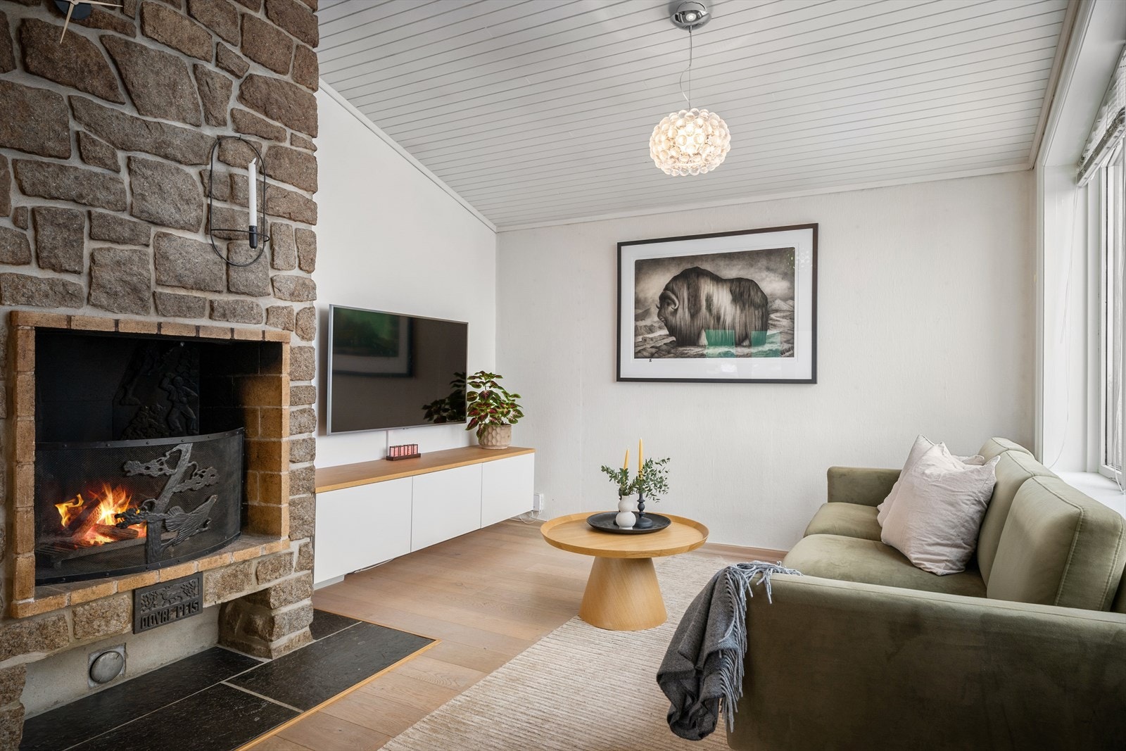 En vinkelstue med peis og formidabel utsikt. Boligen oppleves som gjennomgående luftig og innbydende med en god og lun atmosfære. Galleribilde