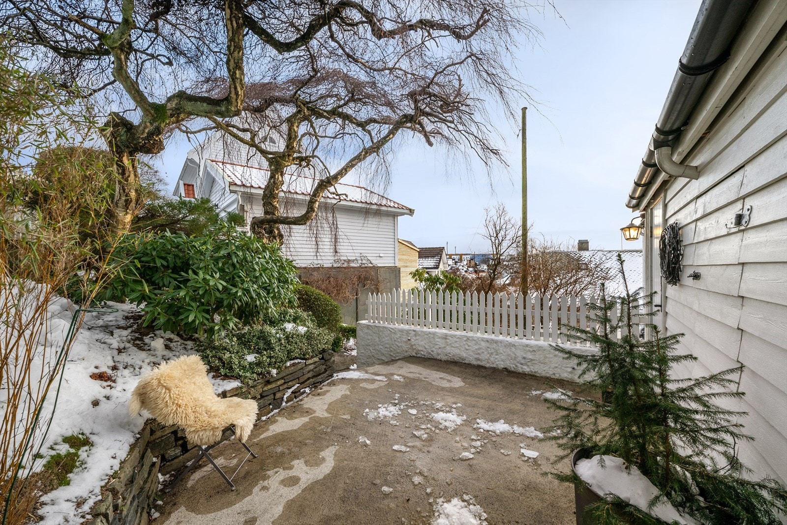 Flotte trær svøper seg over inngangspartiet. En privat oase. Galleribilde