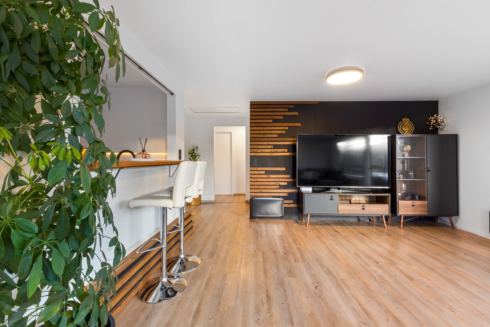 Sitteplasser ved åpning mot kjøkkenet. Loftsluken kan sees i enden av bildet. Døren rett frem er til ett av soverommene. Galleribilde