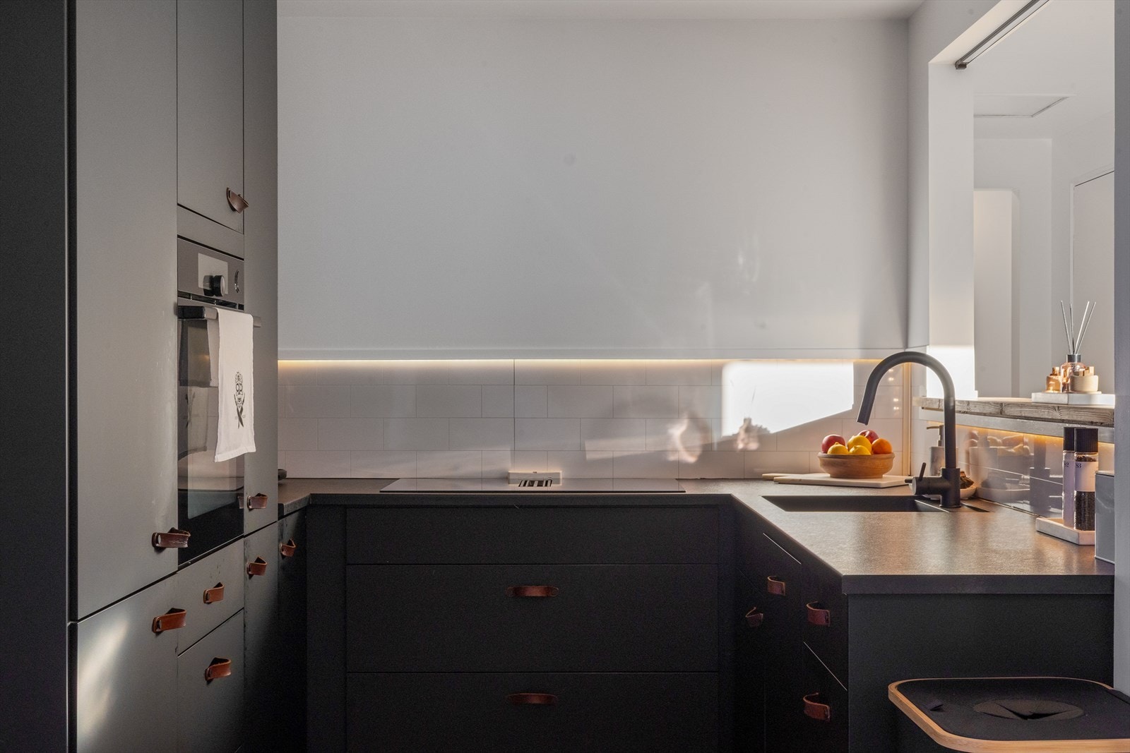 Kjøkkeninnredning med integrerte hvitevarer, samt komfyrvakt. Stekeovnen er plassert i praktisk høyde, og steketopp har innfelt ventilator. Rett og slett lekkert! Galleribilde