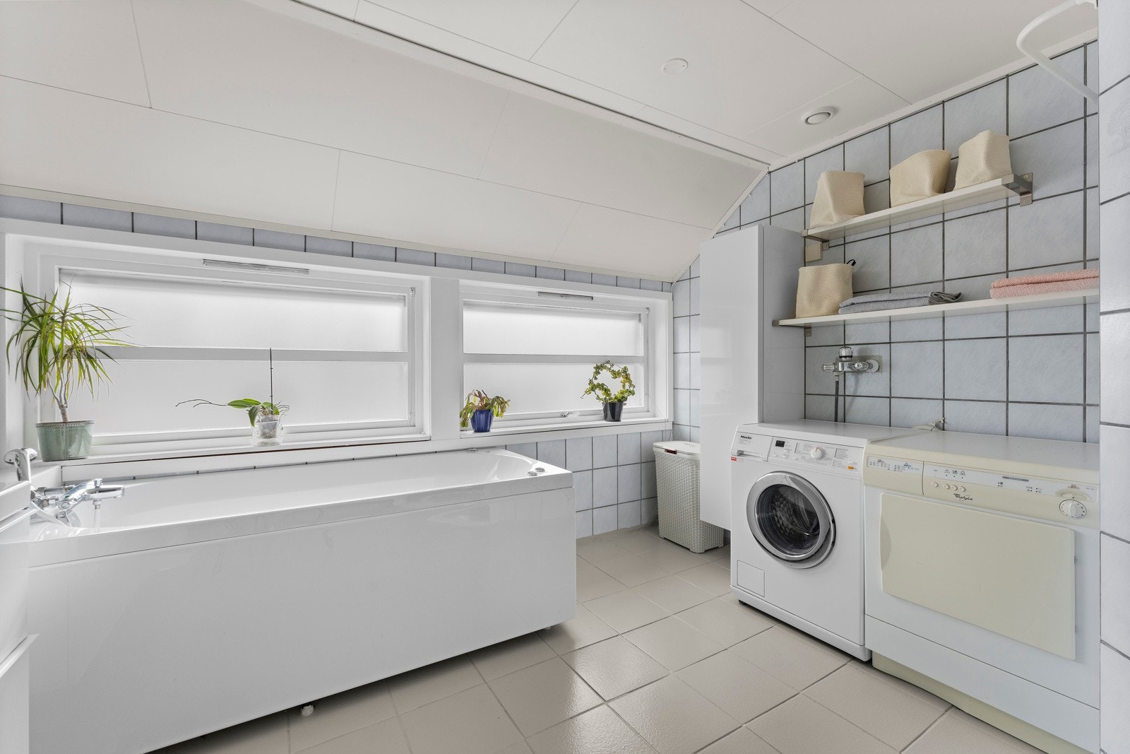 Badet er innredet med servantinnredning med to servanter, toalett, frittstående badekar og opplegg for vaskemaskin. Galleribilde