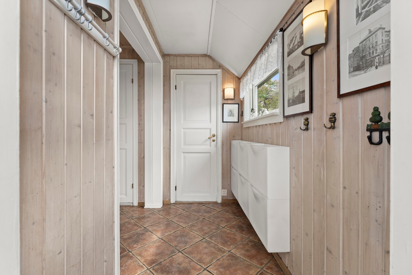 Entréen har flislagt gulv og god plass til å henge fra seg yttertøy og sette fra seg sko. Galleribilde