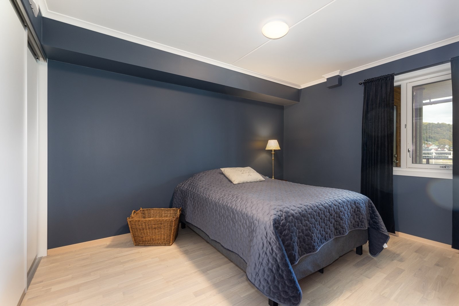 Stort soverom i beroligende blå fargetone, med plass til dobbeltseng og nattbord. Stor skyvedørsgarderobe langs den ene veggen. Rommet er såpass stort at tidligere eier hadde kotorpult på rommet. Galleribilde