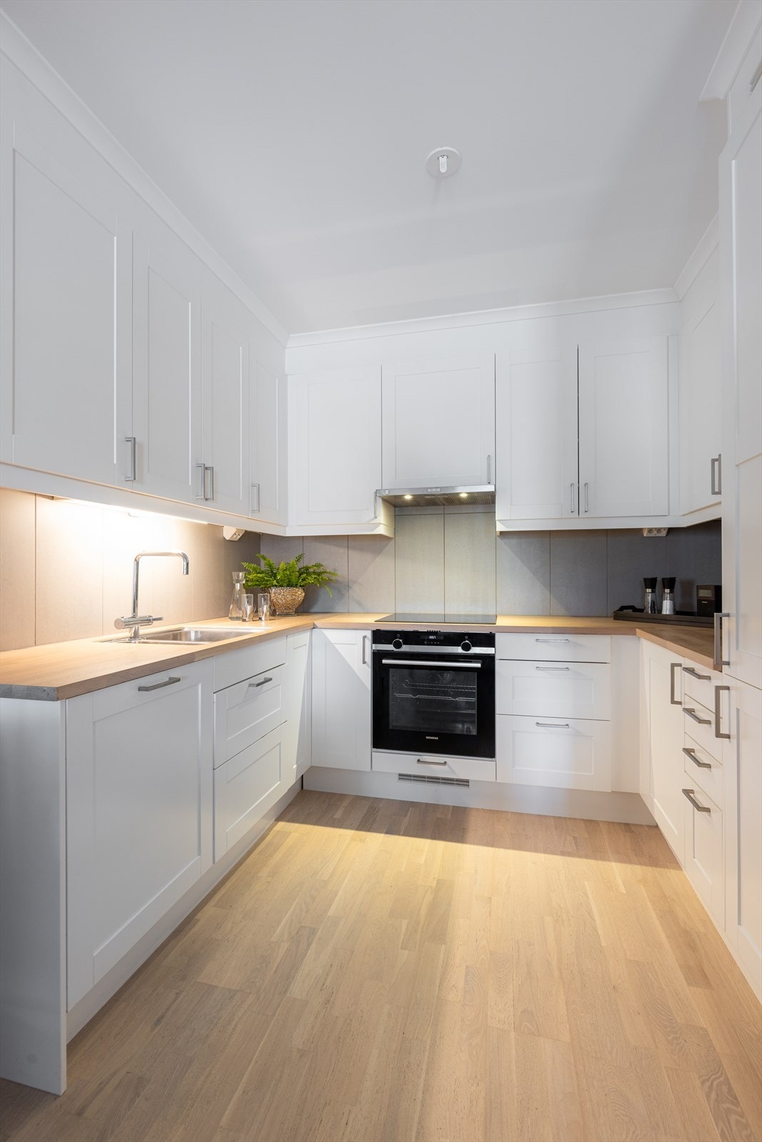 Kjøkkenet har integrerte hvitevarer som oppvaskmaskin, koketopp, stekeovn og kjøl/fryseskap, og over kokesonen er det avtrekk via balansert anlegg. Galleribilde