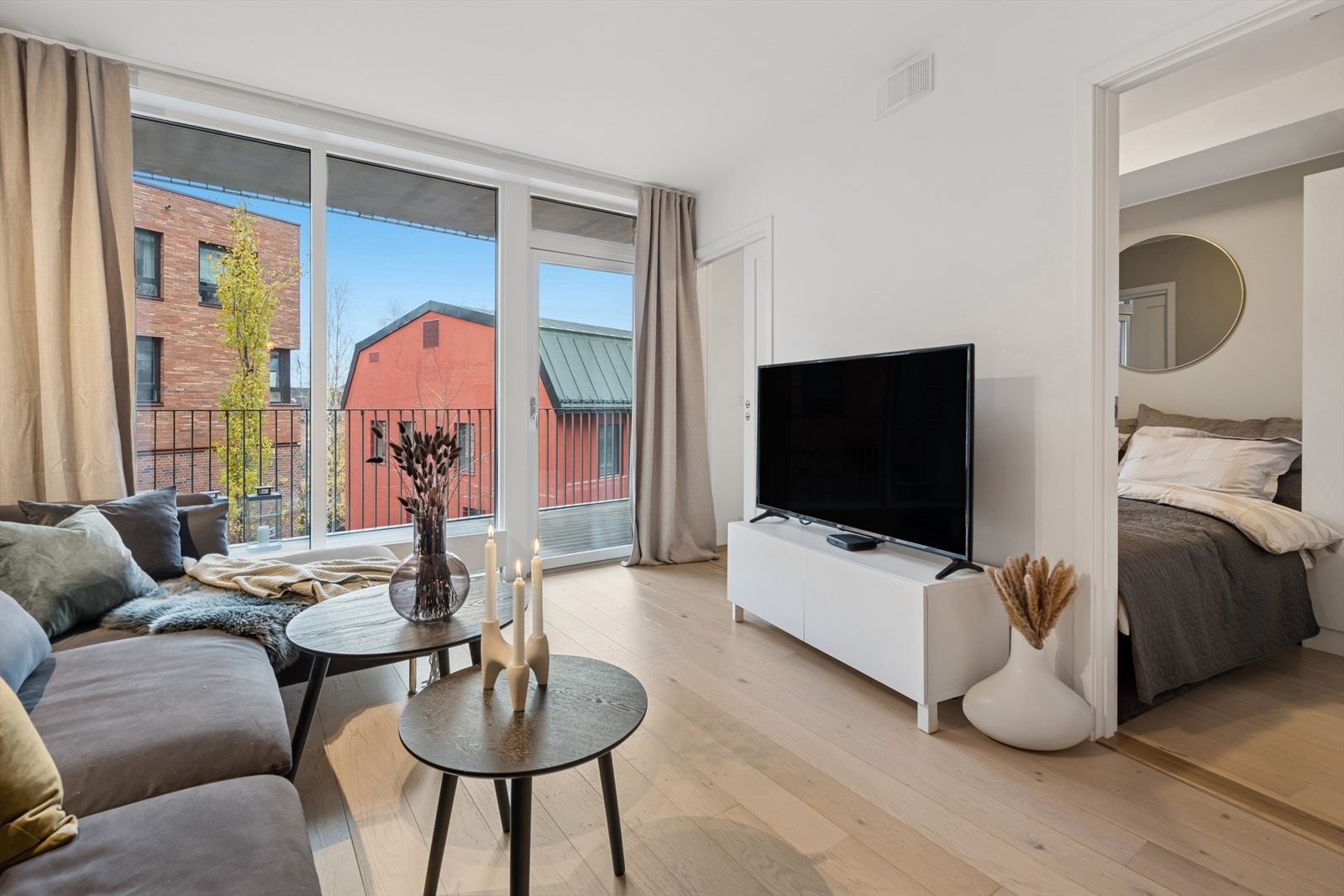 Store vinduer og skyvedør slipper mye lys inn i leiligheten. Galleribilde