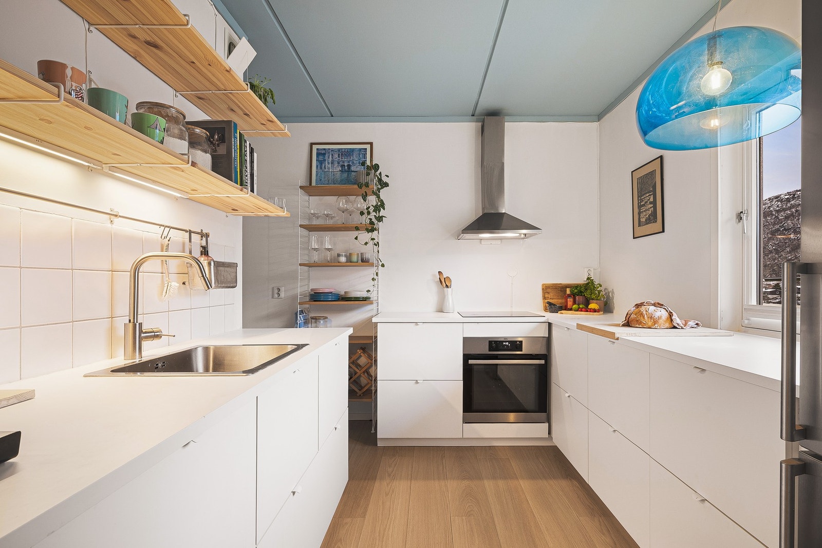 Moderne kjøkkeninnredning fra IKEA med slette, hvite fronter som gir et tidløst rent utrykk. Benkeplaten er utført i laminat og gir gode arbeidsflater. Galleribilde