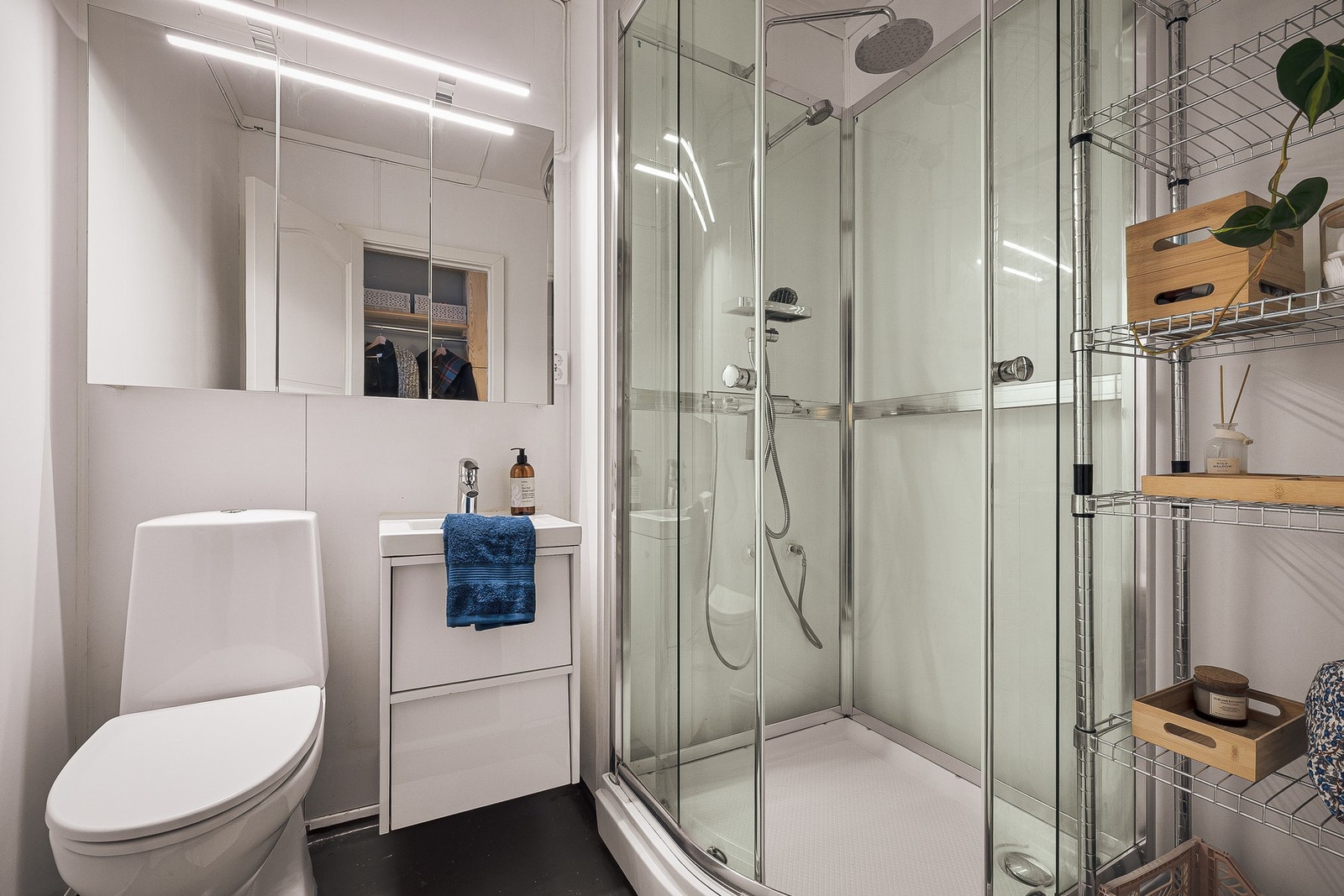 Badet er utstyrt med gulvmontert vannklosett, vegghengt servant med tilhørende skuffeseksjon som gir praktisk oppbevaringsplass, samt vegghengt overskap med speil. Det er installert dusjkabinett som bidrar til å begrense fuktbelastning på øvrige overflate Galleribilde