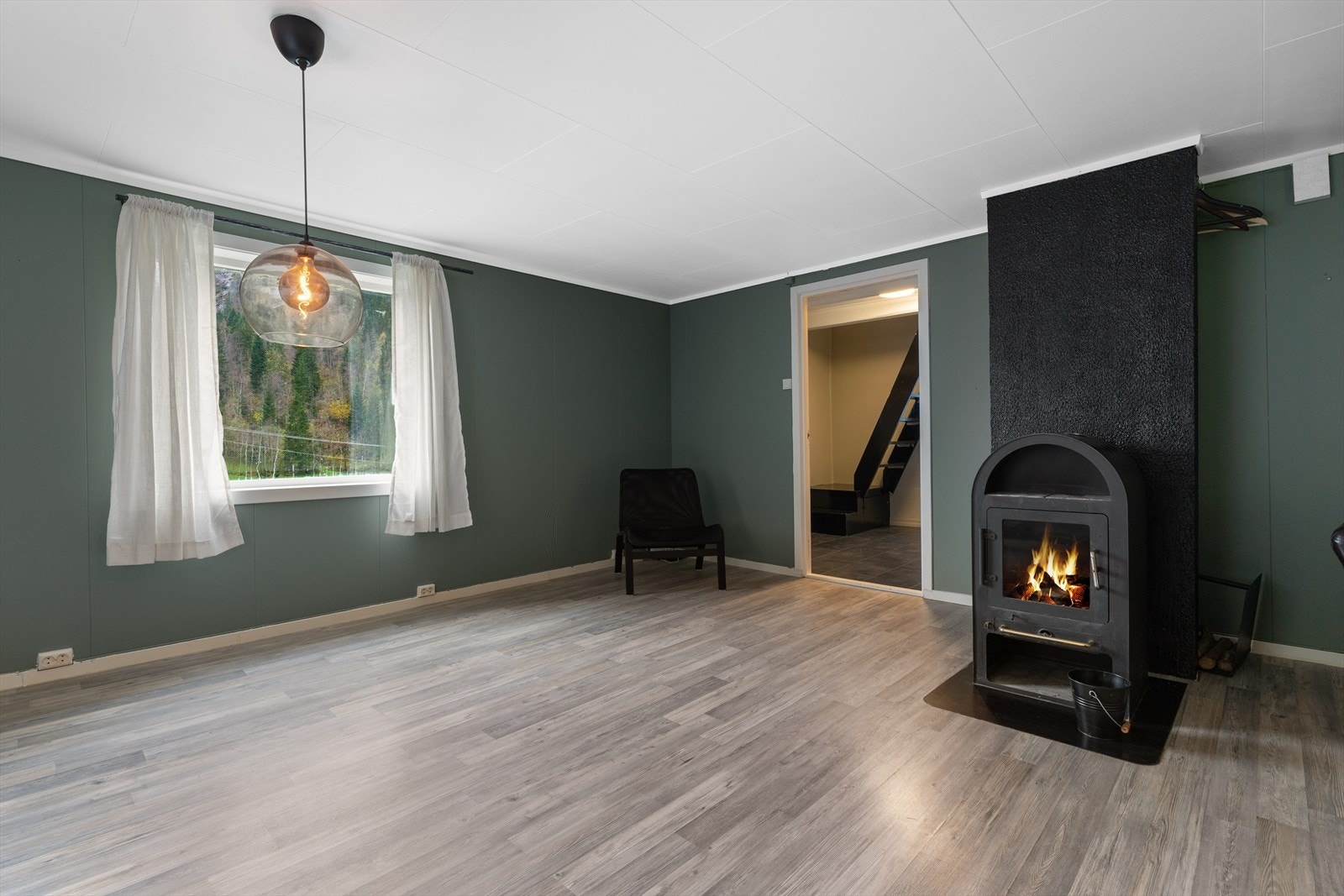 Lys og innbydende stue med peis, store vinduer og moderne gulv. Perfekt for avslapning og hygge. Galleribilde