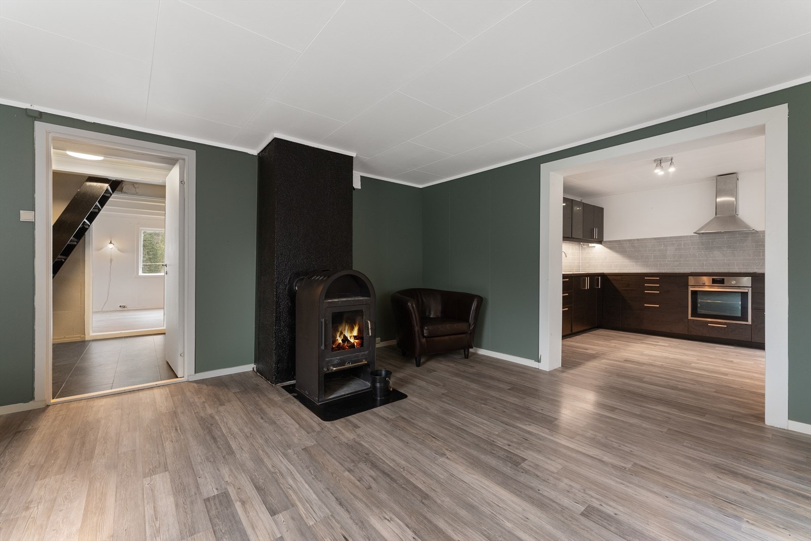 Lys og romslig stue med peis, åpen løsning til moderne kjøkken. Perfekt for koselige kvelder og gjestfrihet. Galleribilde