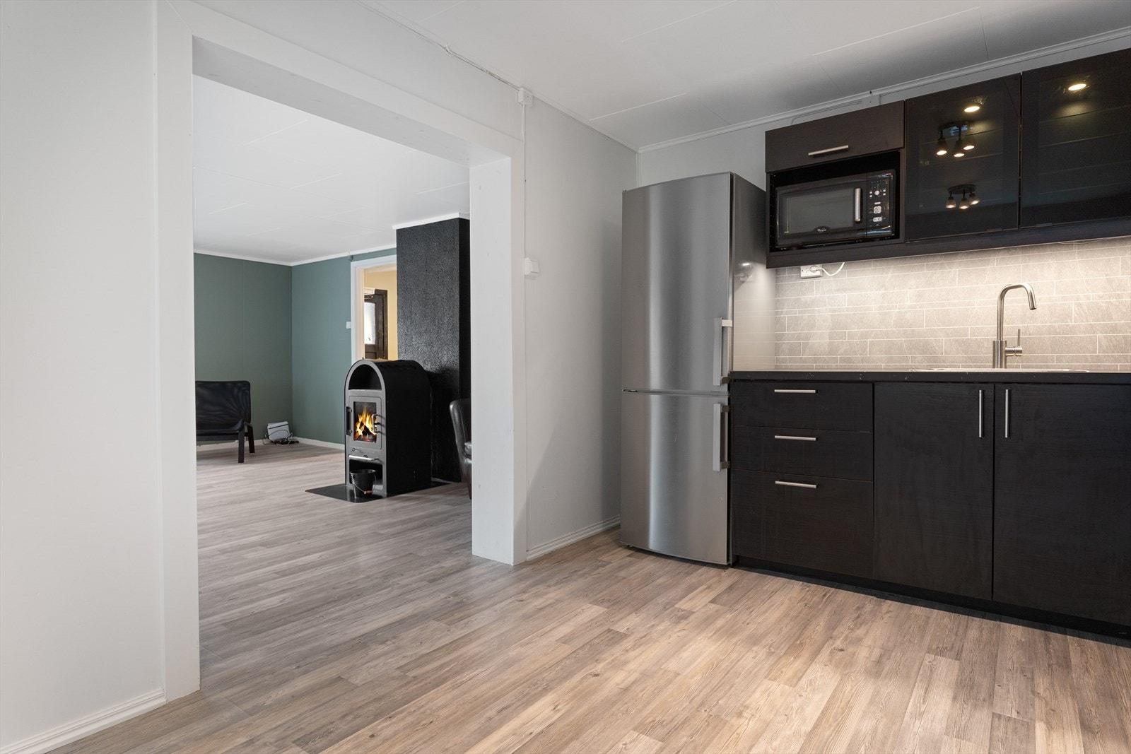 Moderne og lyst kjøkken. Åpen løsning mot stue med vedovn gir en lun og innbydende atmosfære. Galleribilde