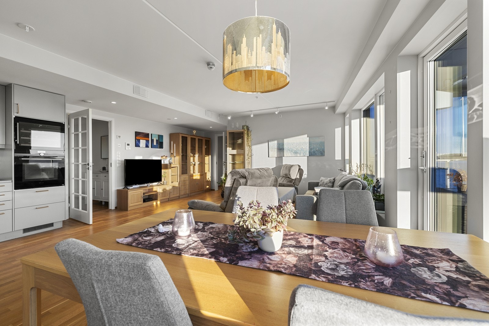 Oversikt over den sosiale sonen, hvor stue og kjøkken henger sømløst sammen. Galleribilde