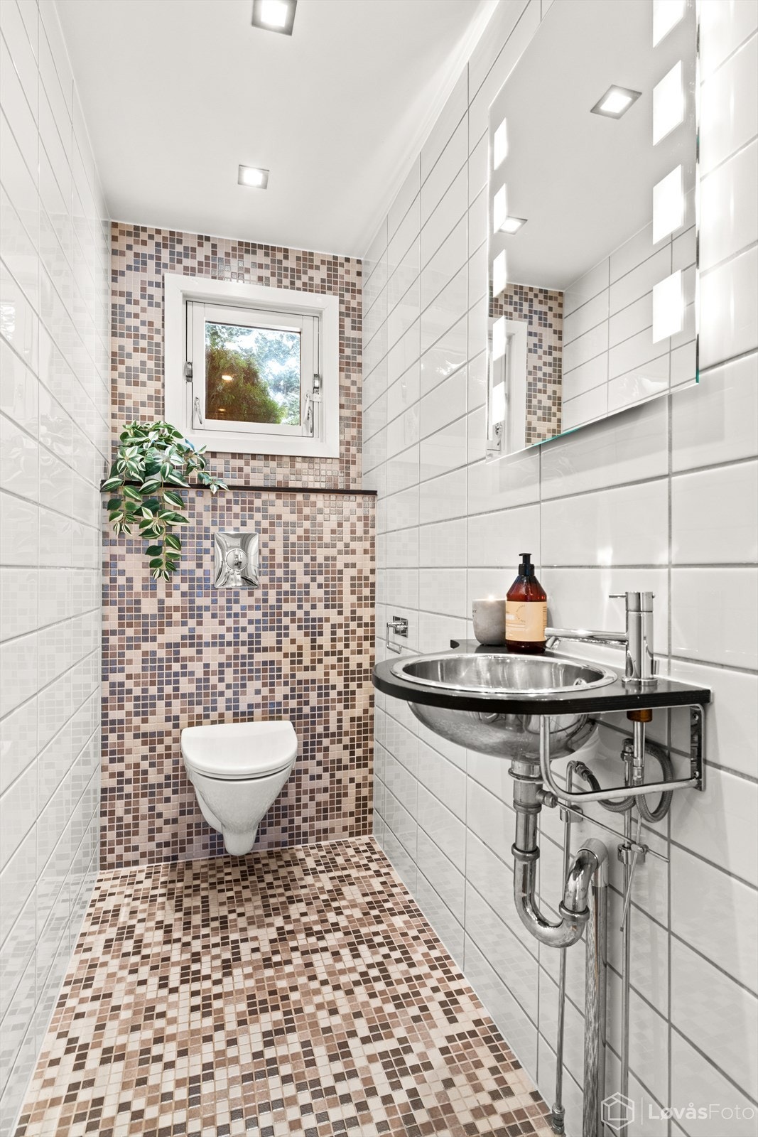 Praktisk, flislagt toalettrom i første etasje med vegghengt toalett og varmekabler. Galleribilde