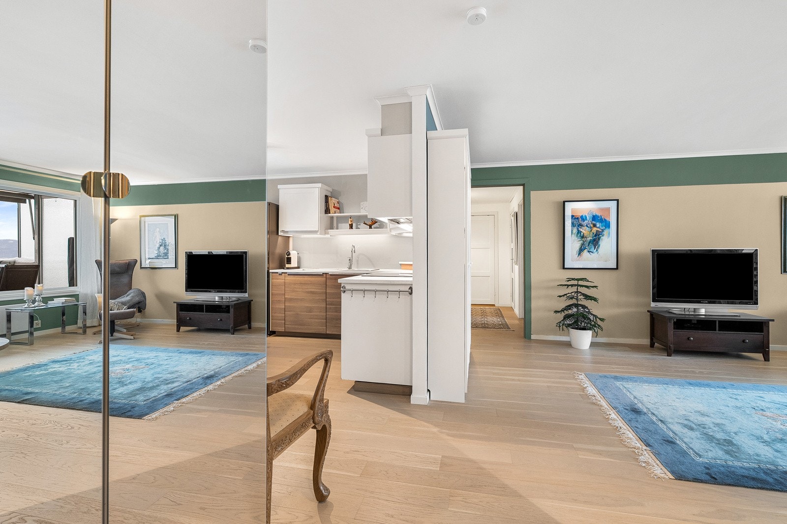 Entré mellom stue og kjøkken, med garderobeskap montert. Galleribilde