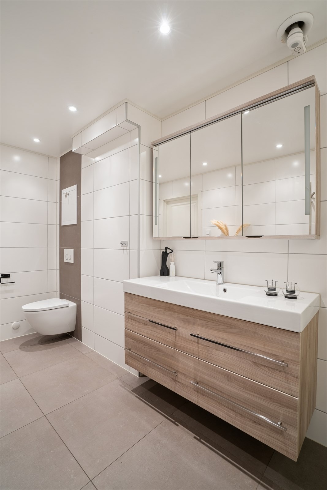 Badet har flislagte vegger og et pent flislagt gulv med store fliser og innstøpte varmekabler for ekstra komfort. Galleribilde