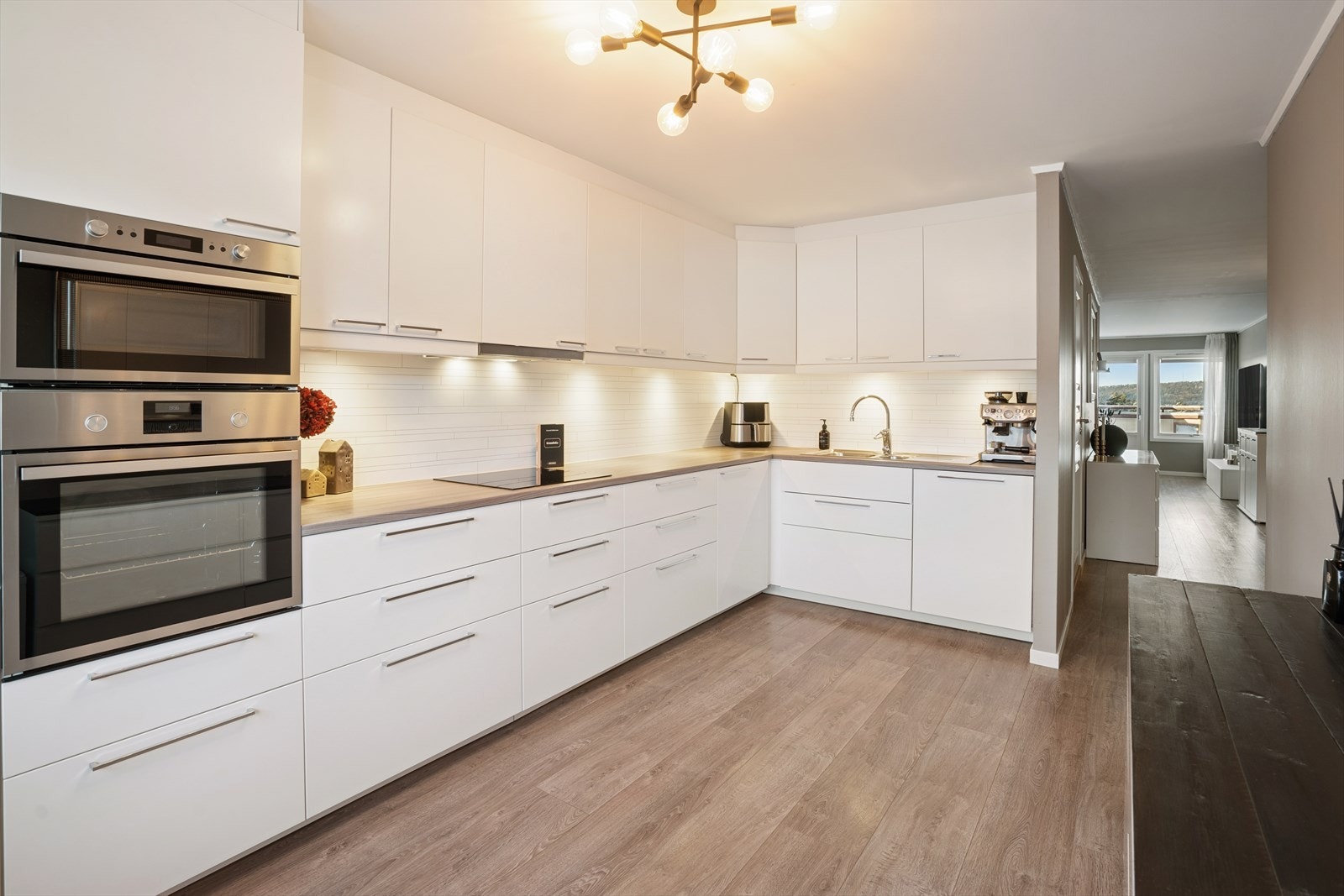 Kjøkkenet er integrert med stekeovn, koketopp, mikrobølgeovn, oppvaskmaskin og kjøl/frys Galleribilde