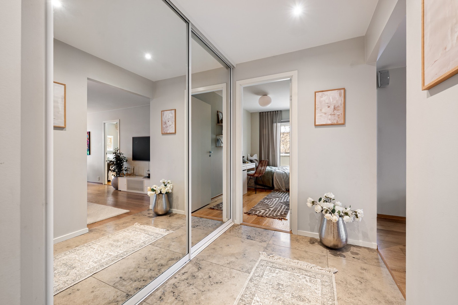 Innbydende entré med stor skyvedørsgarderobe med speilfronter - praktisk oppbevaring som holder hverdagen ryddig. Galleribilde