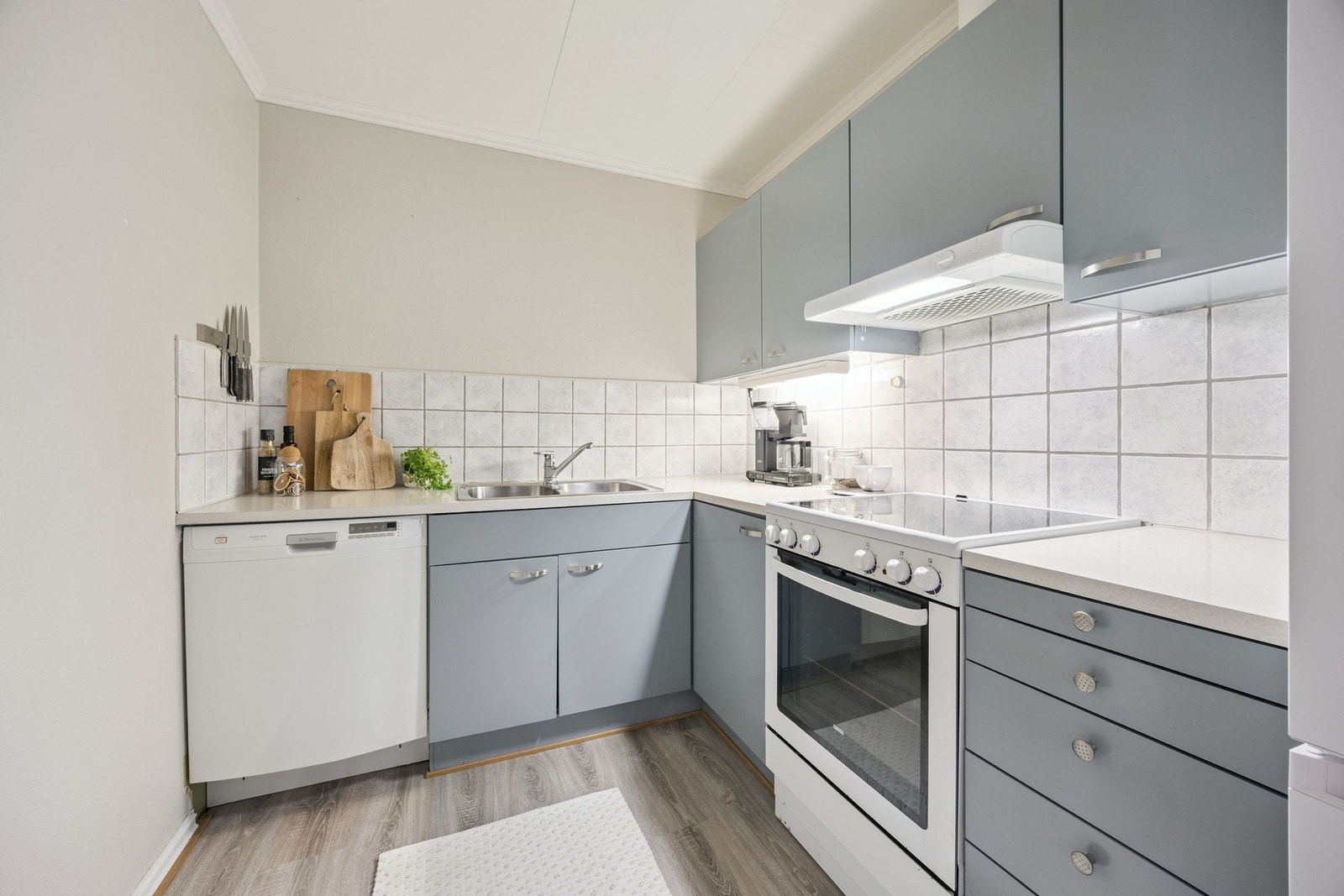 Kjøkkenet har innredning med glatte fronter og laminat benkeplate Galleribilde