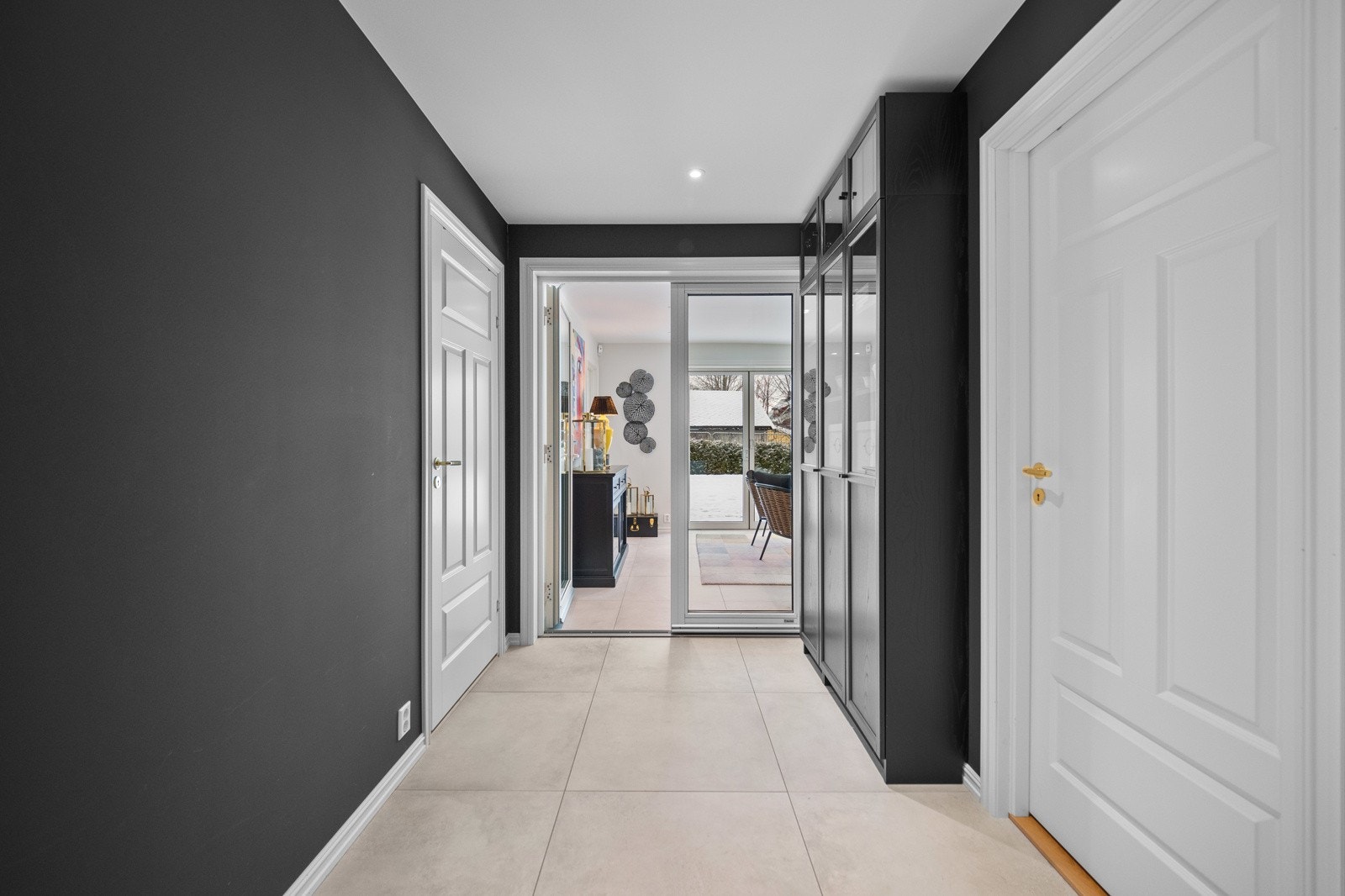 Tofløyede glassdører fører inn til en hagestue med kjøkkeninnredning og god plass til spisegruppe. Galleribilde