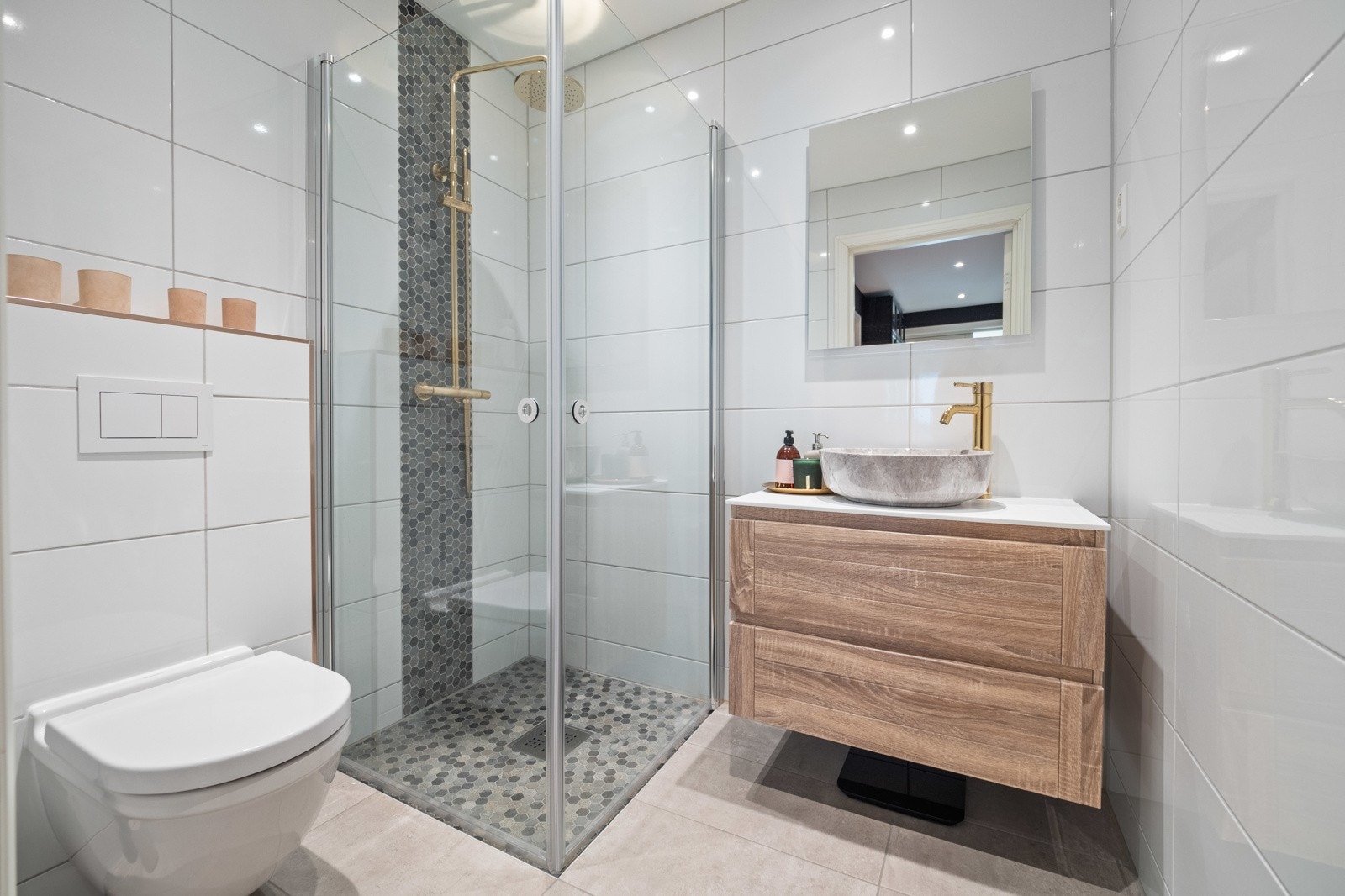 Boligen har to lekre bad og et vaskerom. Dette er badet i første etasje, med pen innredning og regnfallsdusj. Galleribilde