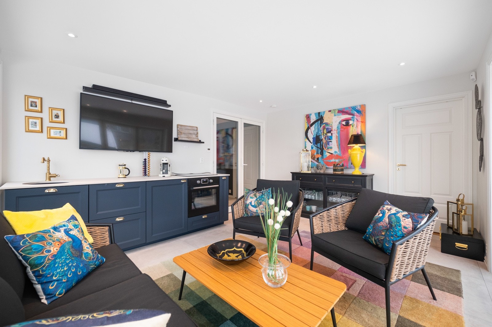 Kjøkkeninnredningen er utstyrt med integrerte hvitevarer og har benkeplate i glasskompositt. Galleribilde