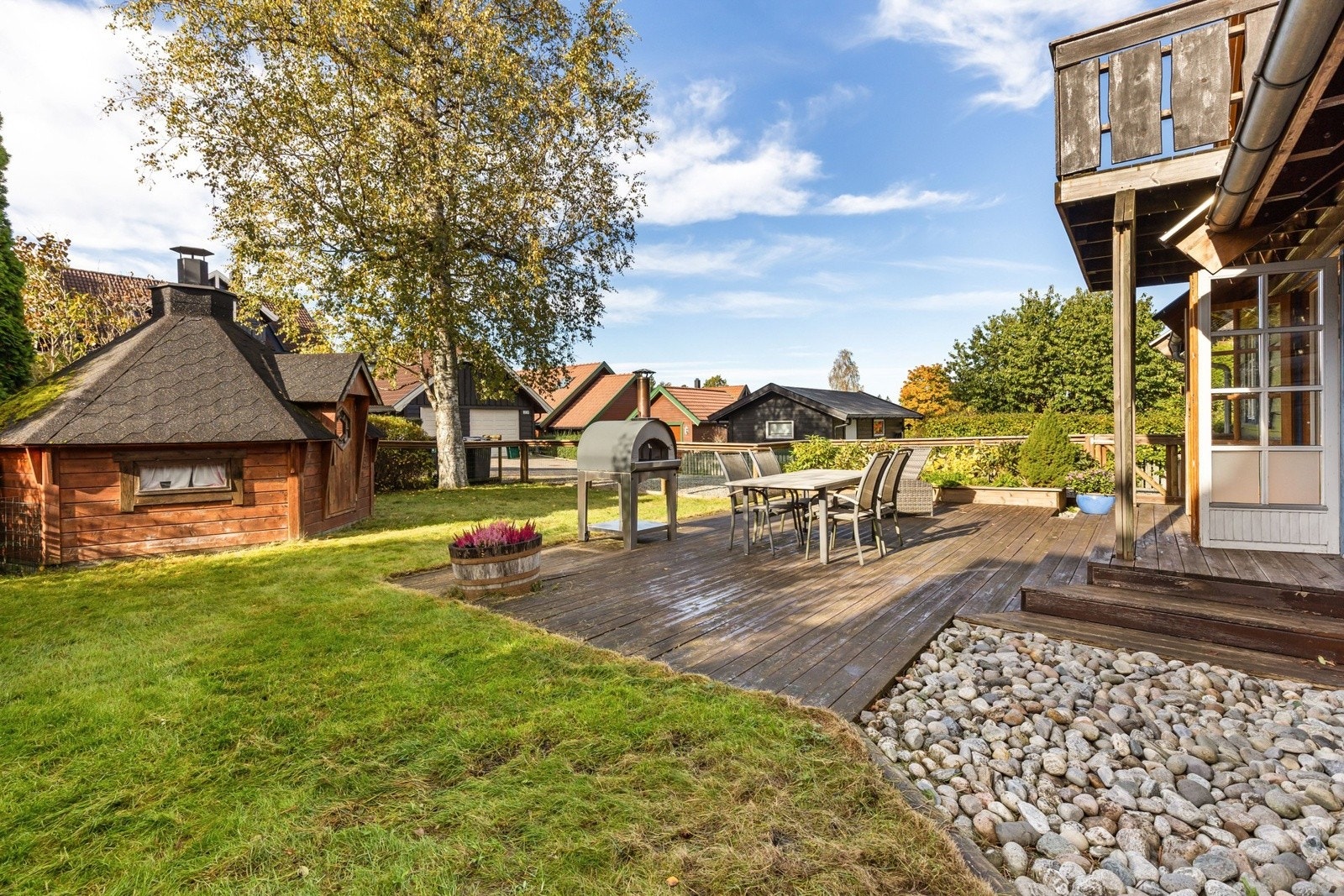 Opparbeidet tomt med terrasseplatting, gressplen og beplantning. Galleribilde