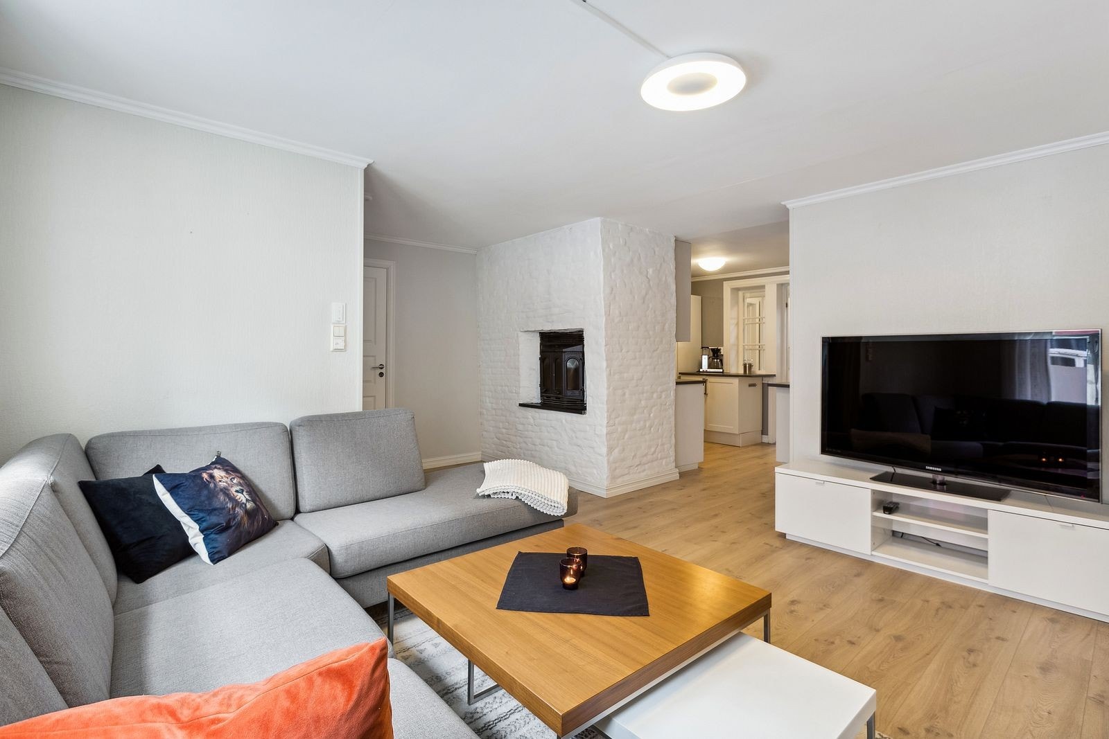 Stuen varmes opp av strøm og vedovn. Stor sofagruppe og dype vinduskarmer. Galleribilde