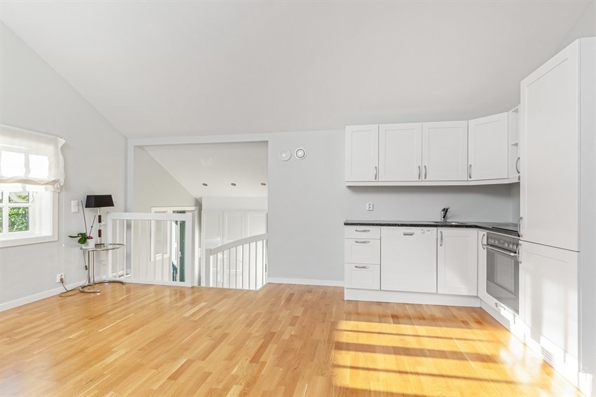 Kjøkkeninnredning i hybelleilighet, med profilert innredning, slimline avtrekksvifte fra Røros Hetta,  laminat benkeplate med nedfelt stålkum og keramisk topp, integrert kjøl/frys og komfyr, oppvaskmaskin.