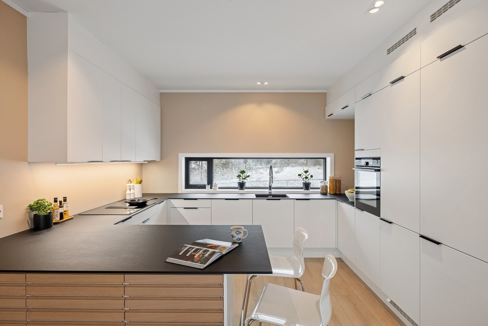 Delikat kjøkkeninnredning med glatte fronter og trykk-laminert benkeplate. Galleribilde